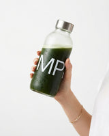 A single hand holding a cold MornPop moringa drink bottle